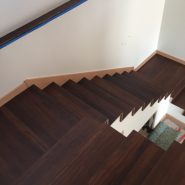 Stairs shown with wood treads and risers with dark stain